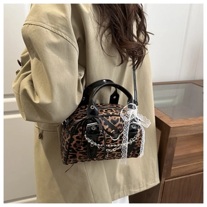 Detail of leopard print baguette bag with lace bow and silver chain strap