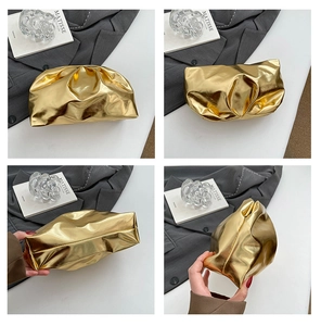 Detail view of metallic gold ruched cloud clutch bag with reflective mirror finish texture