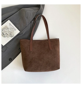 Macro detail of dark brown suede tote bag with textured finish and leather handles