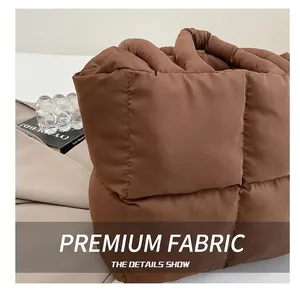 Macro detail of brown quilted tote bag with padded handles and thick puffer texture