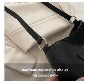 Close-up of silver metal hook and strap attachment on a black faux leather bag