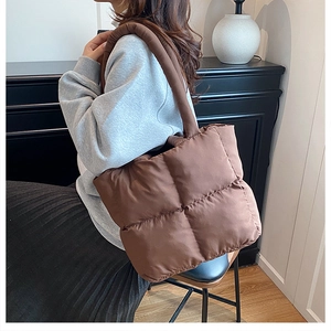 Detail of soft brown quilted puffer tote bag with puffy padded handles and square pattern