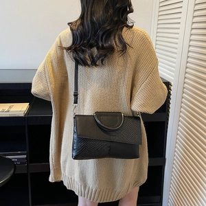Sac à main en cuir noir avec rabat gaufré et poignées métalliques au style décontracté