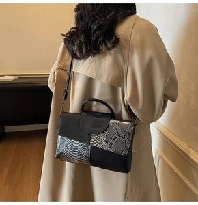 Detail of the chic black and silver snakeskin patchwork handbag on a model's shoulder