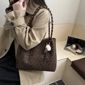 Sac cabas à motif léopard avec poignées tressées et breloque dans un cadre de vie urbain