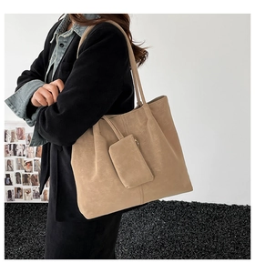 Detail view of a beige matte faux suede tote bag with matching zippered pouch accessory