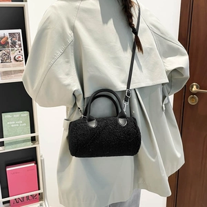 Sac bandoulière cylindrique noir en fausse fourrure d'hiver avec poignées en cuir