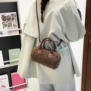 Sac cylindrique en peluche marron avec anses en cuir dans un décor minimaliste chaleureux