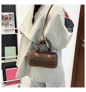 Detail of plush brown teddy fleece cylinder bag with premium leather handles and straps