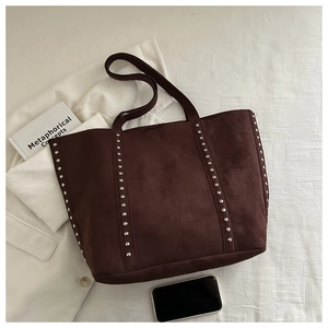 Detail of vintage brown suede tote bag featuring parallel silver rivet studs and long straps