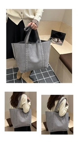 Détail du sac cabas en daim gris avec rivets argentés et larges poignées à la maison