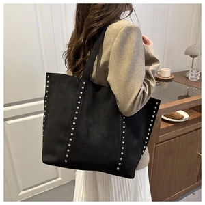 Détail du grand sac cabas noir avec rivets argentés verticaux sur cuir suédé mat