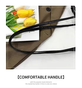Close-up of black leather tote bag strap with reinforced stitching and tulip decor