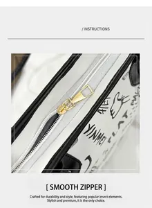 Detailed close-up of smooth gold zipper hardware and graffiti pattern on white leather tote