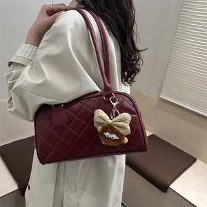 Burgundy quilted leather bowling tote bag with plush monster charm on fashion model