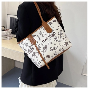 Detail of the oversized graffiti tote bag featuring bear prints and brown leather straps