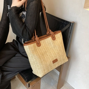 Chic beige straw tote bag with brown leather handles for summer vacation beach trips