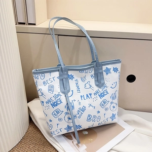 Detail of blue graffiti tote bag showing artistic prints and light blue faux leather straps