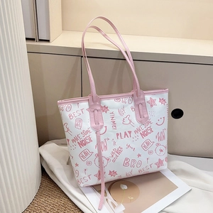 Macro detail of graffiti print tote bag showing pink PU leather handles and urban patterns
