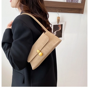Dettaglio di un'elegante borsa sottobraccio in pelle PU beige con fibbia in metallo dorato