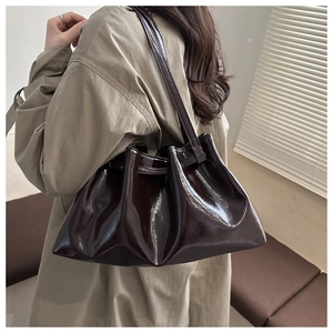 Vue latérale du sac fourre-tout en cuir verni marron foncé avec design plissé tendance