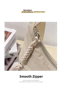 Detail of smooth metal zipper and thick knotted rope puller on beige nylon crossbody bag