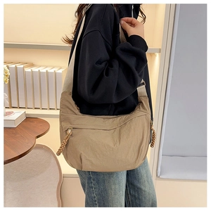 Detail of khaki nylon crescent bag with wide strap and woven zipper puller