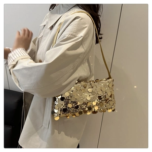 Dettaglio di una borsa a tracolla con paillettes dorate indossata da una modella