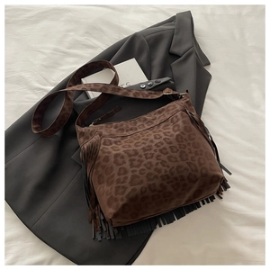 Detail of leopard print suede bag with long fringe tassels and wide shoulder strap