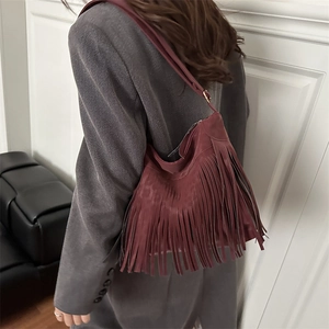 Retro burgundy fringe tote bag in matte leather finish shown on model's shoulder