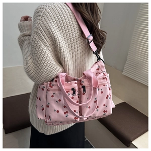 Pink tote bag with cherry print featuring front zipper pockets and nylon strap detail