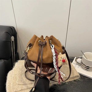Secchiello in pelle scamosciata marrone con tracolla intrecciata e ciondolo in peluche