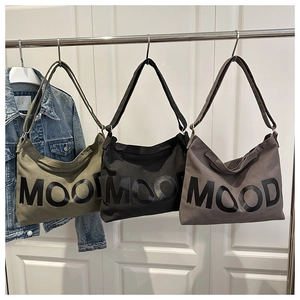 Detailed view of canvas tote bags in olive green, black and grey with MOOD print
