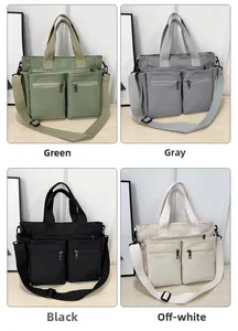 Detail of canvas tote bag showing wide handles and front zipper pockets in four colors