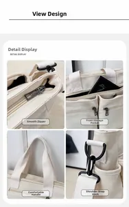 Detail view of white nylon tote featuring metal zippers, multiple pockets, and reinforced straps