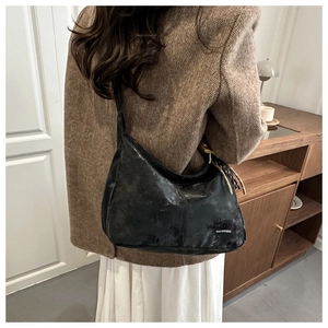 Black vintage hobo bag styled with a brown herringbone blazer in a classic indoor setting