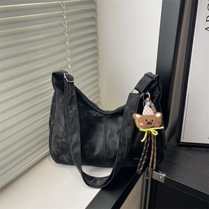 Minimalist black suede tote bag with Tidal lettering and a cute bear plush charm