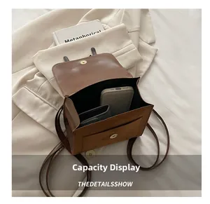 Brown vintage faux leather bag showing internal storage capacity for phone and wallet