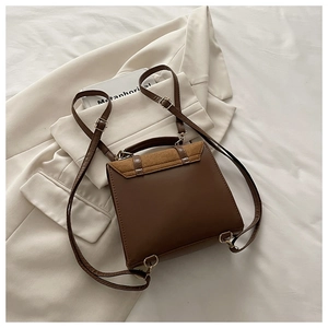Detailed view of vintage brown patchwork backpack on white fabric with casual styling