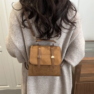 Brown matte suede backpack for women with decorative buckles and slim shoulder straps