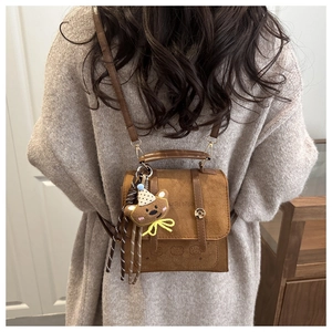 Brown suede crossbody bag featuring a cute bear charm and WITU STUDIO embossed logo