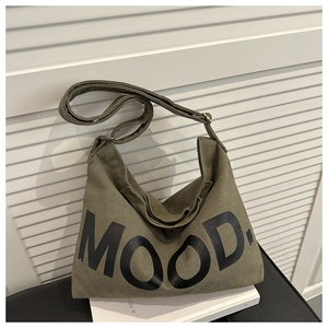 Dettaglio della borsa a tracolla in tela verde militare con scritta MOOD. e tracolla