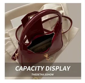 Internal capacity of the dark red patent leather crescent bag showing zipper and lining