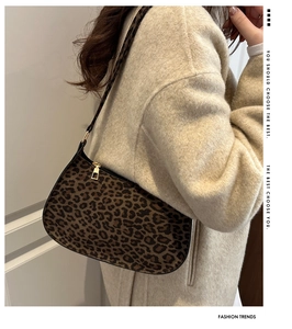 Detail view of leopard print shoulder bag with gold zipper on oatmeal wool coat