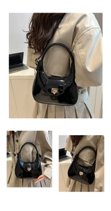 Close-up of black patent leather shoulder bag featuring a glossy finish and gold square lock