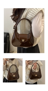 Detail of a brown patent leather saddle bag with gold buckle and adjustable strap