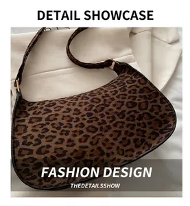 Macro shot of leopard print shoulder bag with crescent shape and gold metal buckle