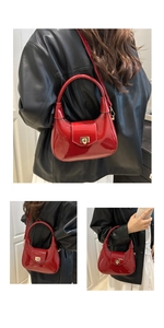 Detailed macro view of the glossy red crescent bag with a gold metal square clasp