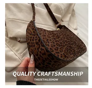 Close-up of leopard print baguette bag featuring suede texture and gold hardware details