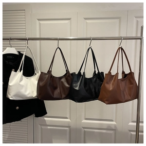 Modern tote bags in four colors hanging on a rack for daily fashion and commute